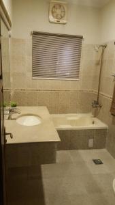 ein Badezimmer mit einem Waschbecken und einer Badewanne in der Unterkunft Mulberry Residence Family Rooms in Islamabad