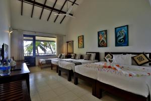 a bedroom with three beds in a room at Sea Rock Villa in Bentota