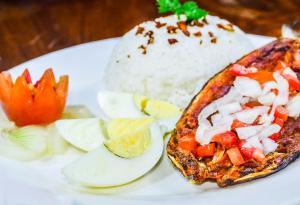 a white plate with a piece of food with rice and vegetables at Skyland Garden Hotel and Resort in Baguio