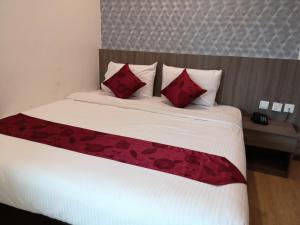 1 dormitorio con 1 cama grande con almohadas rojas en Signature International Hotel China Town en Kuala Lumpur