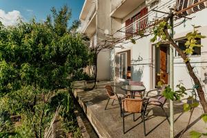 a patio with a table and chairs in front of a building at Apartmani Lovor in Herceg-Novi