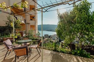 a balcony with a table and chairs and a view at Apartmani Lovor in Herceg-Novi