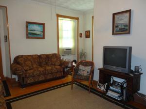 sala de estar con sofá y TV en Historic Hill Inn, en Newport