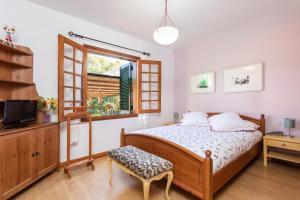 1 dormitorio con cama de madera y ventana en Home2Book Luxury Villa Luna de Tacoronte Pool, en La Laguna