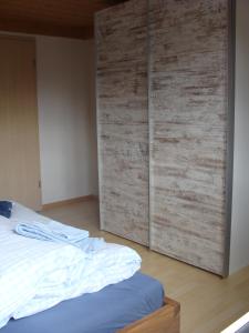1 dormitorio con 1 cama y pared de madera en Chalet Sunnegg, en Adelboden