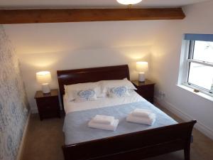 a bedroom with a bed with two towels on it at Meadowside Cottage in Bassenthwaite Lake