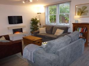 a living room with a couch and a fireplace at Meadowside Cottage in Bassenthwaite Lake