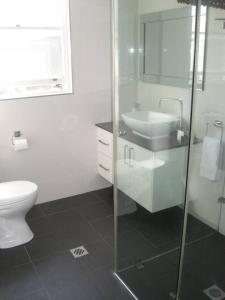Cronulla Beach Break في كرونولا: حمام أبيض مع حوض ومرحاض