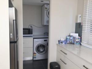 a kitchen with a refrigerator and a washing machine at Cronulla Beach Break in Cronulla