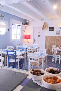 a restaurant with white tables and chairs and bowls of food at Hôtel Les Embruns Sables d'Olonne in Les Sables-dʼOlonne