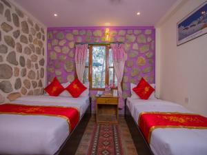 2 letti in una camera con pareti viola e cuscini rossi di Hotel Fewa Corner & Restro a Pokhara