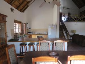 a kitchen with a table and chairs and a refrigerator at Crowe's Nest in Marloth Park