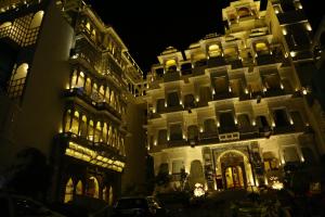 a large white building at night with lights at Udai Kothi in Udaipur