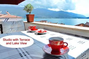 a table with a cup of coffee and a view of the water at Jovanovic Guest House in Ohrid