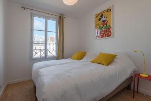 een slaapkamer met een bed met witte lakens en een raam bij Toscane Disneyland apartment BMYGUEST in Serris