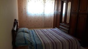 a bedroom with a bed with a window and a dresser at Faridi vacancy appartment in Casablanca