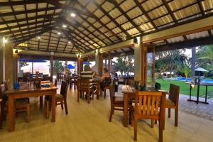 a restaurant with tables and chairs and a view of a golf course at Sea Rock Villa in Bentota