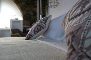 a close up of a bed with pillows on it at Mykonos Pantheon in Kalo Livadi