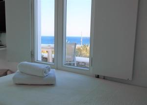 a room with a pillow on a bed with a window at Mykonos Pantheon in Kalo Livadi