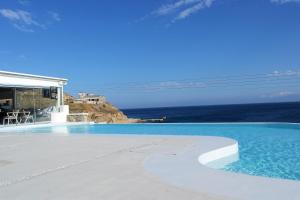 a swimming pool with a view of the ocean at Mykonos Pantheon in Kalo Livadi