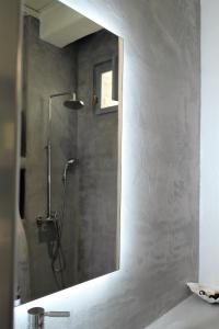 a bathroom with a shower with a mirror on the wall at Mykonos Pantheon in Kalo Livadi