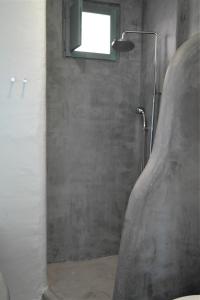 a bathroom with a shower with a window at Mykonos Pantheon in Kalo Livadi