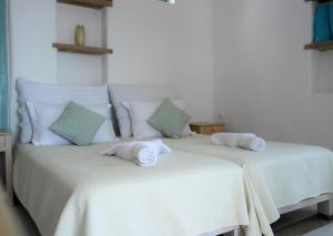 two white beds with towels on them in a room at Mykonos Pantheon in Kalo Livadi