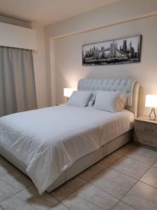 ein Schlafzimmer mit einem großen weißen Bett mit zwei Lampen in der Unterkunft Tony’s Boutique Apartment in Larnaka