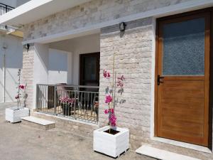 una casa de ladrillo con flores delante de una puerta en Ellie's, en Kardamaina