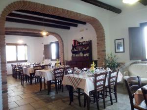 a dining room with tables and chairs and an archway at Al Sentiero in Pollica