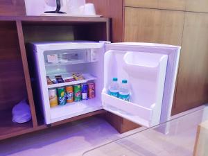 an open refrigerator filled with drinks and water at Hotel Skyking in Dehradun