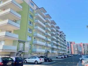un gran edificio de apartamentos con coches aparcados en un aparcamiento en RS Apartments, en Olomouc