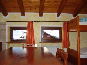 a dining room with a wooden table and two bunk beds at Amemi 2 in Issogne