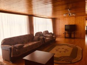 a living room with a couch and a flat screen tv at Villa Premium Qusar in Qusar