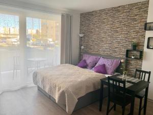 1 dormitorio con cama, mesa y pared de ladrillo en RS Apartments, en Olomouc
