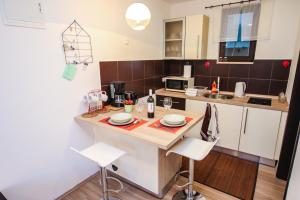 cocina con encimera con armarios blancos y sillas blancas en Apartment Lynn, en Poreč