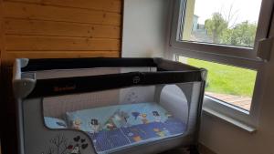a crib with a book in it next to a window at Ferienwohnung am Waldrand in Herdwangen-Schönach +19 photos