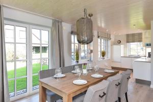 Il comprend une cuisine et une salle à manger avec une table et des chaises en bois. dans l'établissement Gilde Hus, à Westerland