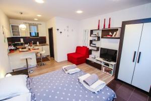 sala de estar con cama y silla roja en Apartment Lynn, en Poreč