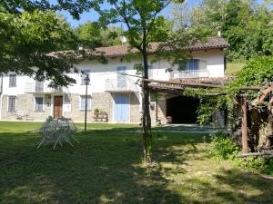 a large white house with a large yard at Il mestiere di vivere -casa vacanze- in Santo Stefano Belbo