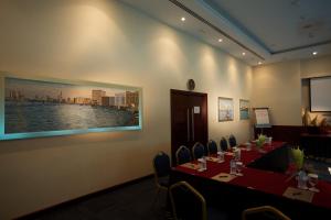 a meeting room with tables and chairs and a painting on the wall at Tamani Marina Hotel & Apartments in Dubai