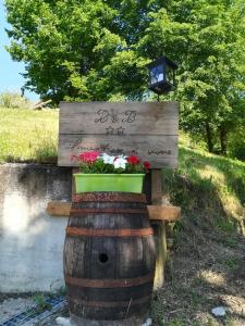 a sign on top of a barrel with flowers at Il mestiere di vivere -casa vacanze- in Santo Stefano Belbo