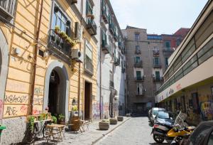 a city street with buildings and a motorcycle parked on the sidewalk at Bed & Breakfast La Mansarda in Naples