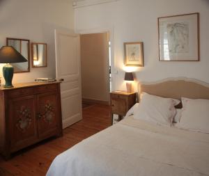 een slaapkamer met een bed, een dressoir en een lamp bij Le Magnolia in La Rochefoucauld