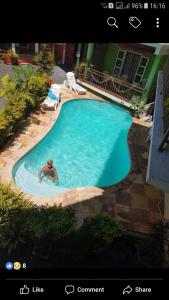 Ein Mann, der in einem großen Pool schwimmt. in der Unterkunft Coeur de paradis villa in Pereybere