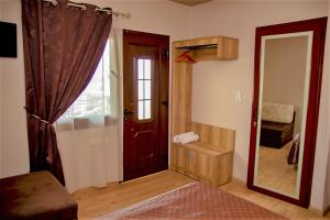 Habitación con puerta, espejo y dormitorio. en Dimitra House en Stavros