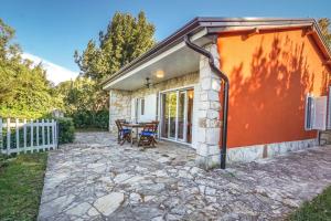 a small house with a table and a patio at Beach House Lucy in Crveni Vrh