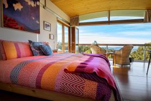 a bedroom with a bed with a view of the ocean at Hobart Hideaway Pods in Kingston
