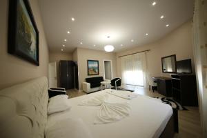 a living room with a white bed and a couch at Hotel Holiday in Koplik