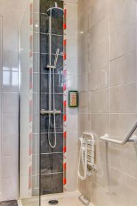 a shower with a glass door in a bathroom at Hotel Le Berry in Saint-Nazaire